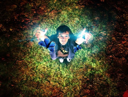 Photo Of A Man Looking Up With Light In His Hands And Throwing Out Blue Butterflies