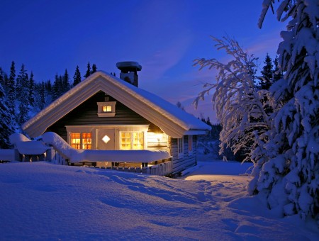 Snow Covered Brown Cottage In The Country At Night