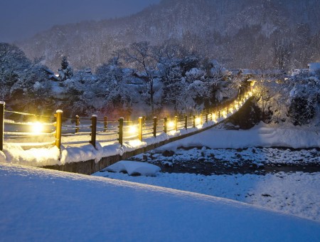 Brown Wooden Fence With Yellow Lights By Snow Field During Nighttime