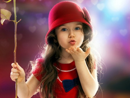 Shallow Focus Photography Of Girl In Red And Blue Dress Wearing Red Hat Holding Brown And Green Twig Giving Flying Kiss