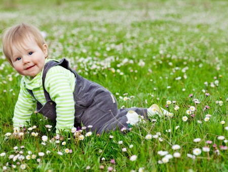 Child Wearing Gray Jumpsuit Crawling On Green Field During Day