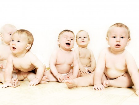 5 Babies Sitting And Smiling With White Background
