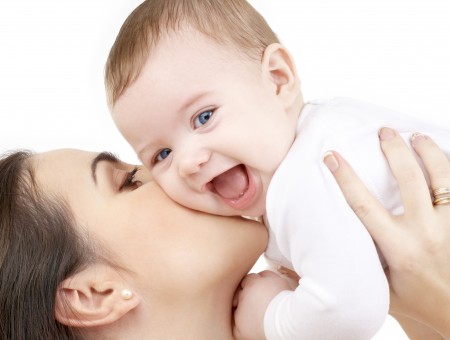 Brunette Woman Holding Up And Kissing A Baby