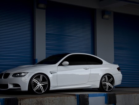 White Coupe Beside Blue Metal Garage Door BMW M3