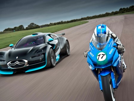 Blue Sports Motorcycle Passing Black Sports Car