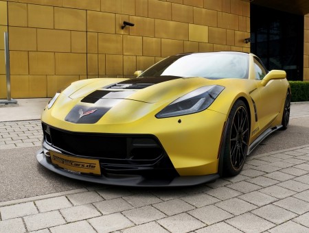 Yellow And Black Coupe Sports Car Parked Beside Yellow Concrete Wall