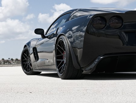 Black Corvette Sports Car Parked On Beige Sands During Daytime