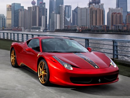 Red And Black Ferrari Sports Car Across City Buildings