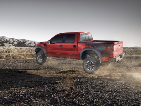 Red And Black Ford F150 Raptor On Dirt Troad