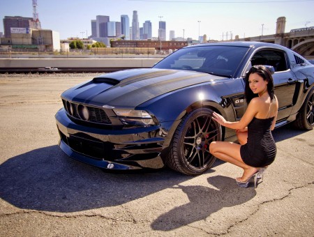 Woman Wearing Black Tube Dress Sitting Beside The Black Car Outdoor During Day