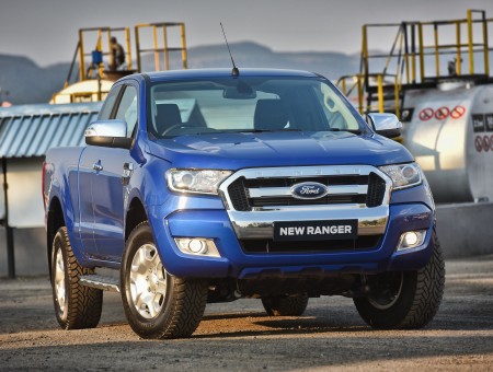 Blue Ford New Ranger On Gray Road Near White Water Tank During Daytime