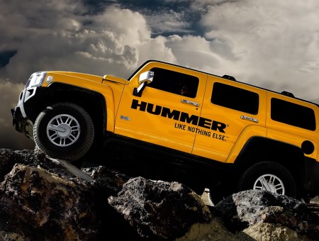 Yellow And Black Hummer H2 Climbing On Rock Hill