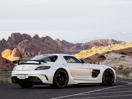 White Mercedes Sports Car With Mountain Range In Sight