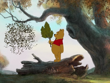 Winnie The Pooh Holding Leaves Standing On Tree Trunk