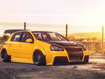 Yellow And Black Hatchback With Black Hood With Roofs Scoop Under Orange Sunset