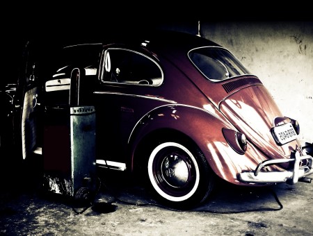 Red Volkswagen Beetle Parked Beside Concrete Wall