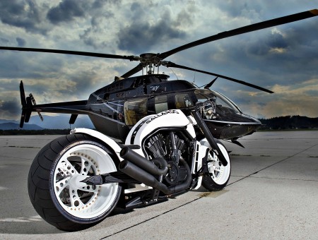 Black Helicopter On The Ground Next To A White And Black Motorbike