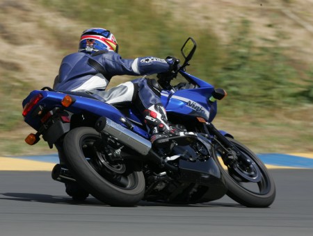 Man Wearing Red And Blue Helmet Riding Blue And Black Sports Bike On The Road During Daytime
