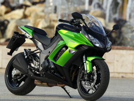 Green And Black Sports Bike On Grey Concrete Floor During Daytime
