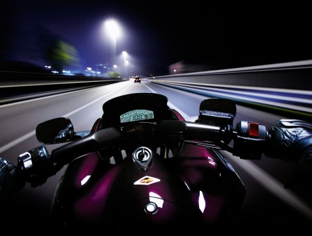 Person Driving Motorcycle Traveling On Road During Nighttime
