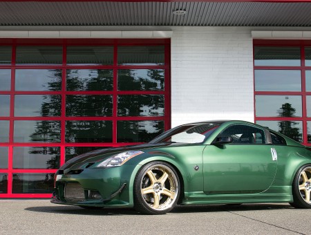 Green Nissan 370z Coupe Sports Car Parked Beside Building