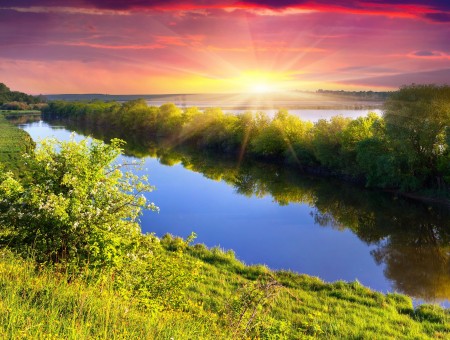 River Between Grass Ground Under Blue Sky With White And Orange Clouds During Sunrise