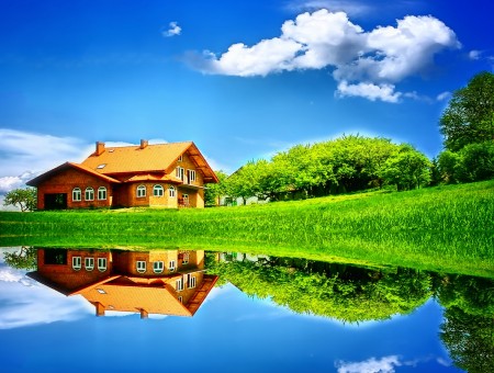 Brown House On Green Grass Fields Near Body Of Water Under White Clouds And Blue Sky During Daytime
