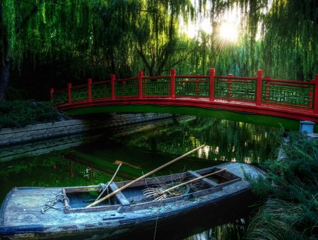 Red Metal Bridge By Green Water With White Boat During Daytime
