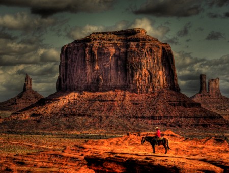 Man Riding Horse In Desert Looking At The Plateau
