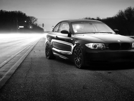 Grayscale Photo Of The Car In The Middle Of The Road At Night