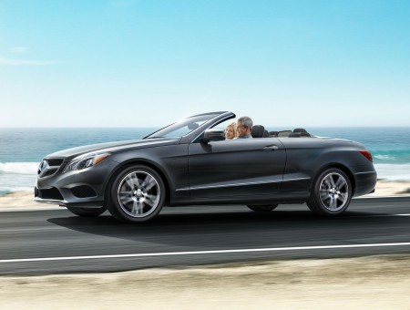 Man And Woman Riding Grey Mercedes Benz Convertible Car Running On Road