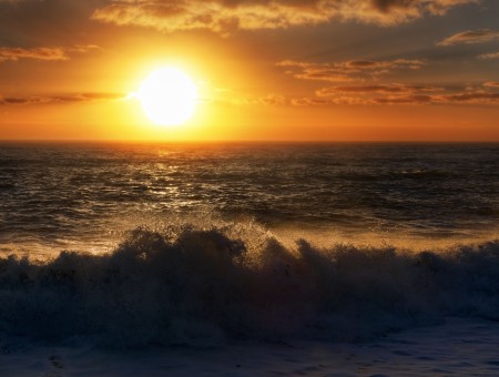 Sunset Over The Horizon With Cloudy Sky And Wavy Sea