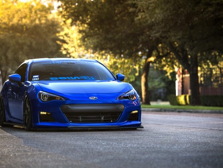 Blue Sports Car With Trees Behind During Daytime