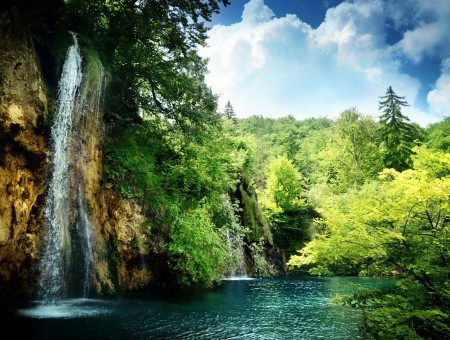Waterfalls In Forest Under Blue Sky And White Clouds