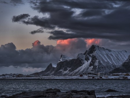 Snow Mountain Near In Sea Under White Clouds During Sunset