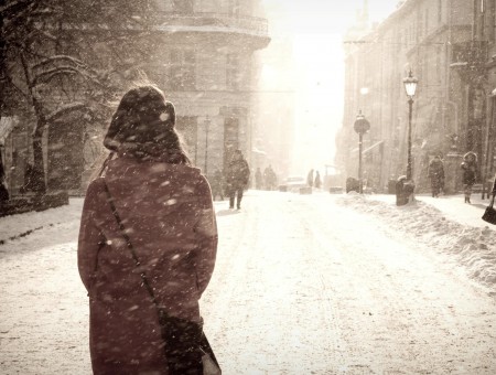 Person In Gray Coat Walking On Road Covered With Snow