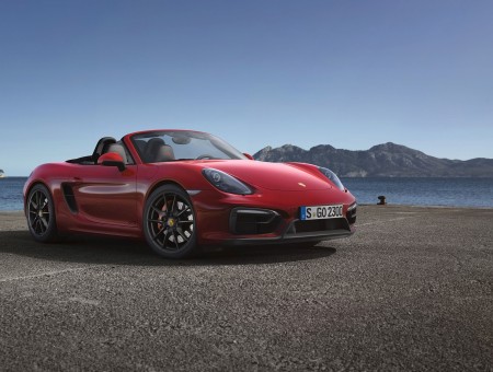 Red Porsche Boxster Parked On Grey Pavement During Daylight