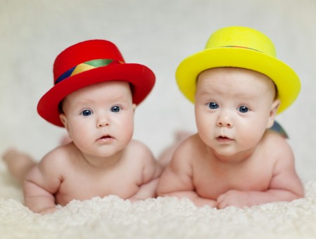 Baby Wearing Red Hat Beside Baby Wearing Yellow Hat