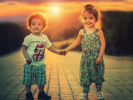 Baby Boy And Girl Holding On Hands On Concrete Road During Sunset