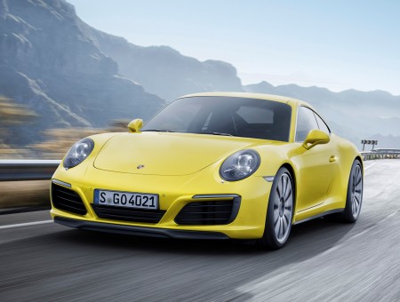 Yellow Porsche 911 Driving On Mountain Road At Daytime