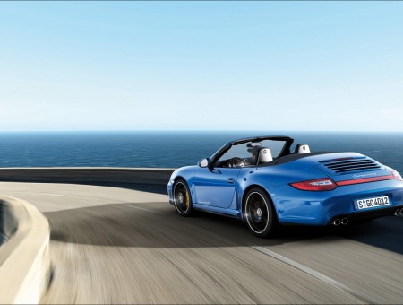 Blue Porsche Boxster On Paved Road In Panning Photography