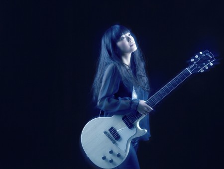 Woman With Dark Hair Holding A White Guitar
