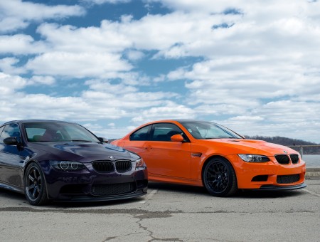 Black BMW M5 And Orange Bmw M5 Parked During Daytime