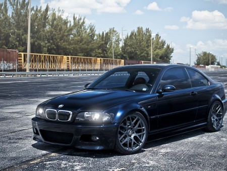 Black BMW M3 Series On Gray Concrete Wall Under Blue Sky And White Clouds During Daytime