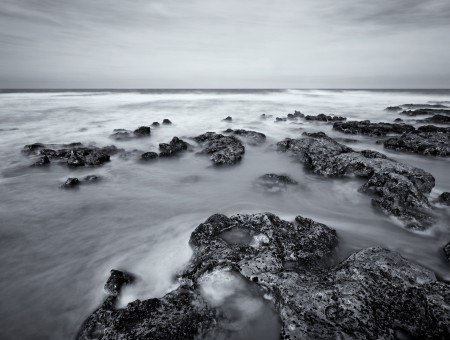 Sea Waves Crashing Rocky Beach Shore In Time Lapse Photograph In Grayscale