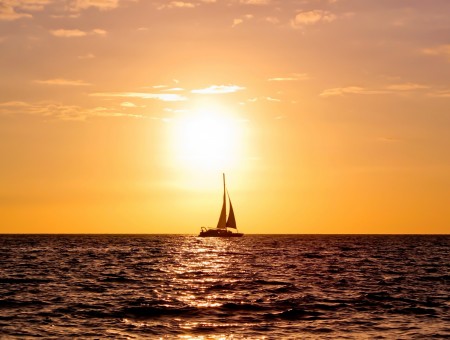 Sailboat On Ocean Water During Sunset