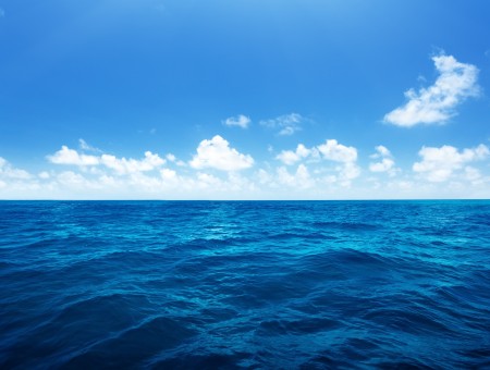 Ocean Under Blue And Sky And White Clouds During Daytime