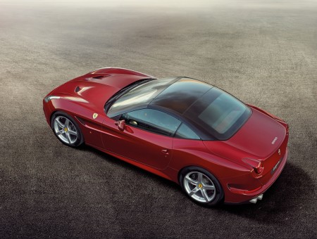 Red Ferrari California Parked On The Grey Dirt Ground