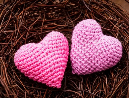 Two Pink Heart Shaped Textiles On Brown Basket