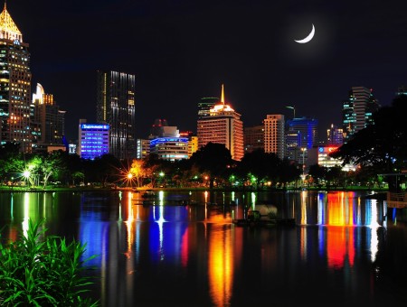 City Skyline And Crescent Moon At Night Time